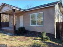 Tan colored house with a covered porch and a well-maintained lawn at 605 Bolton Nw Rd, Atlanta, GA 30331