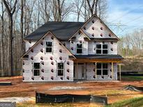 Two-story home featuring black roof, bright windows, and a covered front porch at 142 Asa Moseley Rd, Mcdonough, GA 30252