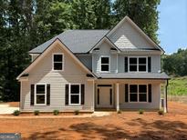 Charming two-story home features a classic design with gray siding, black shutters, and a welcoming front porch at 142 Asa Moseley Rd, Mcdonough, GA 30252