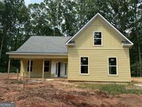 Newly constructed yellow house with white trim, a covered porch, and large windows at 150 Asa Moseley Rd, Mcdonough, GA 30252