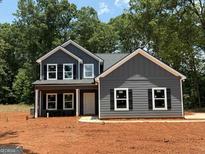 New construction features a gray exterior, black shutters, covered porch, and professional trim work at 148 Asa Moseley Rd, Mcdonough, GA 30252