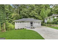 Newly renovated house with a freshly paved driveway and a well-maintained lawn at 1991 Marvin Sw Ln, Atlanta, GA 30311