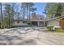 Stunning home featuring a spacious driveway and attached two-car garage at 505 River Valley Rd, Sandy Springs, GA 30328