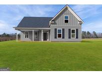 Charming two-story home featuring a well-manicured lawn and classic architectural details at 99 Oak Road, Locust Grove, GA 30248
