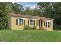 Charming yellow brick home featuring well-maintained front lawn and dark shutters at 1144 Kipling Se St, Atlanta, GA 30315