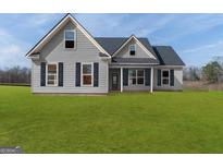 Charming gray two-story home with well-maintained lawn and traditional design elements at 123 Oak Road, Locust Grove, GA 30248