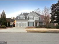Two-story house with three-car garage and manicured lawn at 4106 Creekview Ridge Dr, Buford, GA 30518