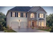 Two-story house with light-colored siding, a brick front, and a three-car garage at 13232 Tolstoy Drive, Covington, GA 30014