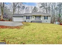 Gray house with white trim, a grassy yard, and a driveway at 800 Andrew Bailey Rd, Sharpsburg, GA 30277