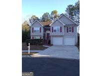 Two-story house with attached double garage and red accents at 3590 Stephens Creek Pl, Loganville, GA 30052