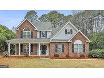 Two-story brick home with a covered porch and landscaped yard at 1312 Yarborough Dr, Peachtree City, GA 30269