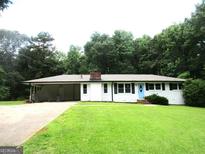 Charming single-story home with a spacious lawn, covered carport, and mature trees at 215 Elliott Rd, Mcdonough, GA 30252