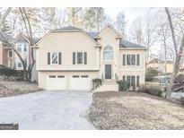 Two-story house with attached two-car garage and manicured lawn at 208 Tennis Court Nw Ln, Kennesaw, GA 30144