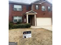 Brick two-story house with attached garage and landscaped yard at 11547 Hathaway Dr, Hampton, GA 30228