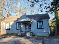 Charming single-story home featuring a covered porch, classic windows, and a compact deck at 4692 College St, Forest Park, GA 30297