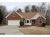 Brick ranch house with attached garage and landscaped yard at 3533 Saddlebrook Dr, Loganville, GA 30052
