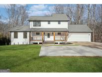 Beautiful two-story home featuring a charming front porch and attached two car garage at 3939 Hamilton Mill Rd, Buford, GA 30519