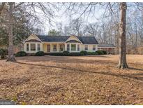Ranch style home with large yard, covered porch, and mature trees at 130 Seneca Pl, Fayetteville, GA 30215