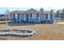 Ranch style home with green accents and a landscaped yard at 70 Grove Creek Dr, Locust Grove, GA 30248