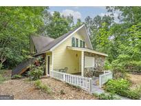 A-frame style house with stone accents and a white picket fence at 731 Airline Rd, Mcdonough, GA 30252