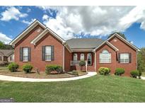 Charming brick home with well-manicured lawn and inviting entrance, showcasing its curb appeal at 253 Edenwylde Ct, Hampton, GA 30228