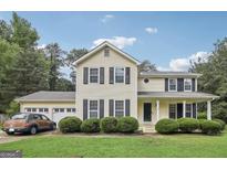 Two-story house with a two car garage and landscaped lawn at 543 Banks E Rd, Fayetteville, GA 30214