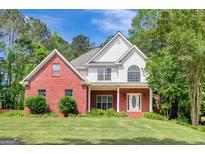 Charming two-story brick home featuring a well-maintained lawn and inviting front porch at 90 Barrington Grange Dr, Sharpsburg, GA 30277