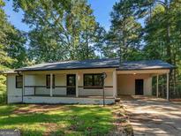 Newly renovated home with carport and charming front porch at 1999 Hampton Locust Grove Rd, Locust Grove, GA 30248