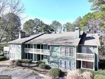 Two-story building with green exterior, balconies, and wooded views at 4676 Vinings Central Run Se # 104, Atlanta, GA 30339