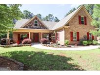 Brick house with red shutters, front porch, and landscaped yard at 900 Eskew Rd, Mcdonough, GA 30252