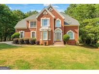 Brick two-story house with a large front yard and mature trees at 308 Bell Isle, Mcdonough, GA 30252