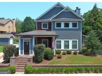Two-story craftsman home with gray siding, brick accents, and a charming front porch at 10 Plum Blossom Ln, Hampton, GA 30228