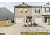 Two-story townhome with gray siding, white garage door, and small front yard at 4937 Lower Elm St, South Fulton, GA 30349
