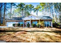 Brick ranch home with attached garage and landscaped yard at 1391 Lakeview Pkwy, Villa Rica, GA 30180