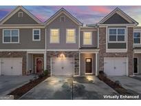 Charming townhome exterior with a one car garage and tasteful stone and brick accents, showcasing curb appeal at 6401 Shalks Crossing Dr, Lithonia, GA 30058