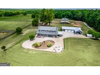 Aerial view of a home on a large lot with barns and paddocks at 3170 Double Bridges Rd, Rutledge, GA 30663
