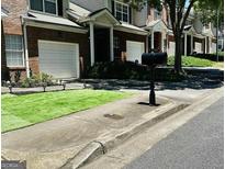 Two-story home with attached garage, manicured lawn, and mailbox at 2567 Laurel Nw Cir, Atlanta, GA 30311