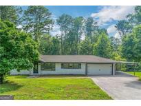 Charming single-story house with a well-maintained lawn and a covered carport at 1322 S Hicks Nw Cir, Conyers, GA 30012