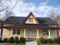 House exterior featuring a charming yellow facade, and a spacious front yard at 41 W Main St, Hampton, GA 30228