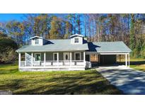 Gray house with white trim, a porch, and a carport at 5125 2Nd St, Morrow, GA 30260