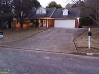 Charming single Gathering home featuring a brick facade, white trim, and a spacious driveway at 25 Brookstone Ct, Covington, GA 30016