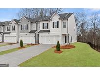 Beautiful townhome featuring white brick, a covered entrance, and an attached one car garage at 313 Sound Cir # 140, Stockbridge, GA 30281