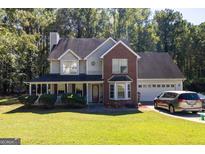 Two-story brick home with a covered porch and attached garage at 245 Mckenzie Dr, Stockbridge, GA 30281