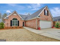 Brick house with attached garage and landscaping at 105 Parks Pl, Sharpsburg, GA 30277
