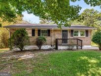 Brick ranch house with a yard, steps, and dark door at 151 Andover Dr, Jonesboro, GA 30238