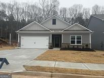 Newly constructed home with gray siding, white garage door, and landscaped lawn at 435 Prescott Way, Villa Rica, GA 30180