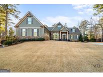 Two-story house with stone and green siding, welcoming porch, and landscaping at 8445 Nolandwood Ln, Villa Rica, GA 30180