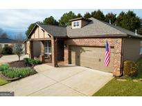 Brick ranch home with 2-car garage, landscaping, and a covered porch at 511 Bonneset Ct, Canton, GA 30114