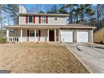 Charming two-story home featuring a welcoming front porch, stone accents, and a two-car garage at 5427 Forest Pines Dr, Lithonia, GA 30058