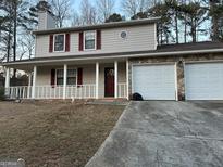 Charming two-story home featuring a cozy front porch and an attached two-car garage at 5427 Forest Pines Dr, Lithonia, GA 30058